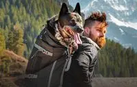Man met hond in rugzak
