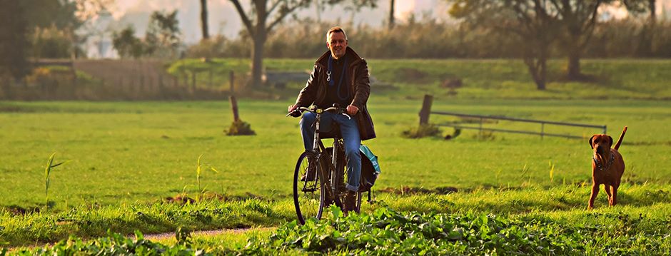 Man fietst samen met zijn hond